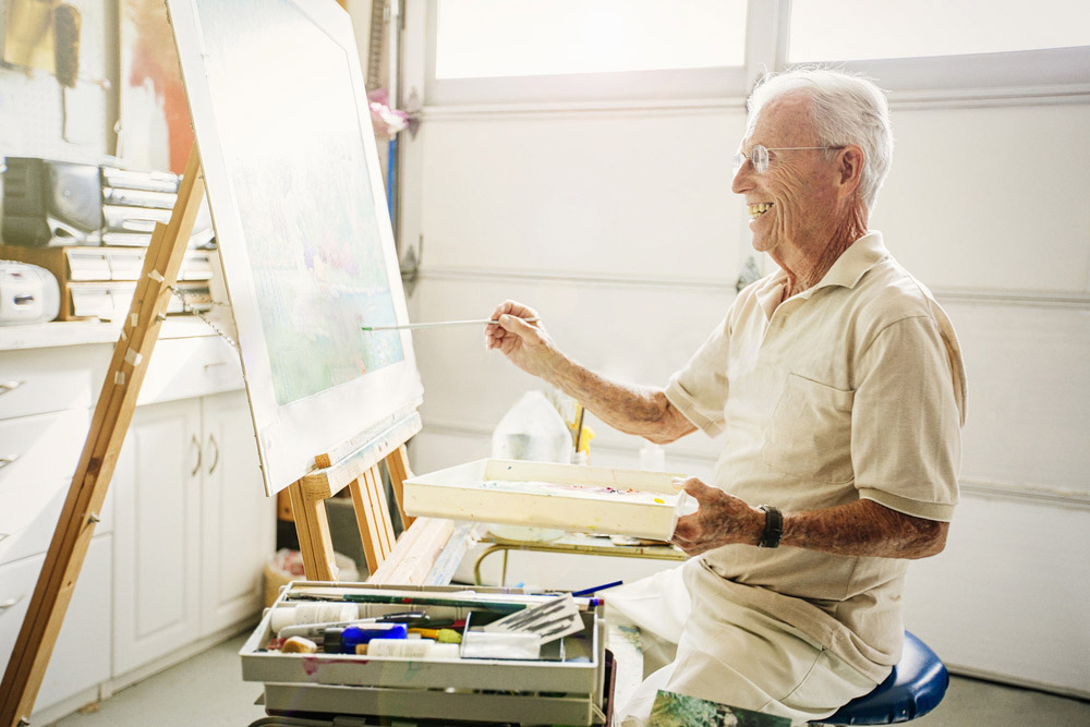 Older man in garage painting.